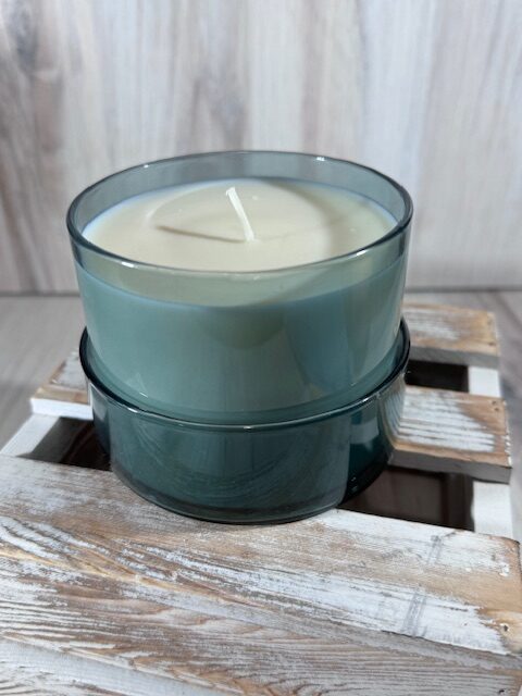 Soy and coconut wax blend candle in a teal round glass container with lid.